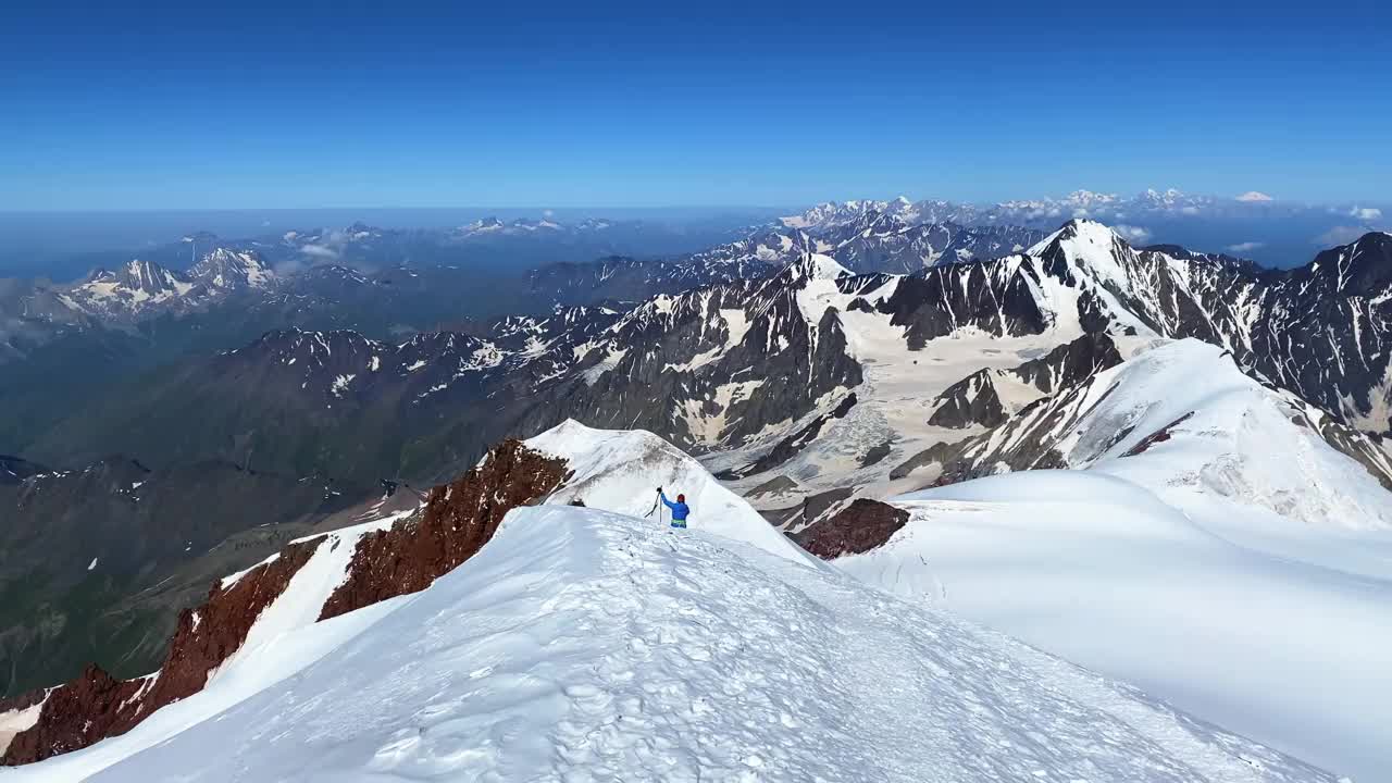 一名登山者从卡兹别克山顶下来。山脉、岩石和小山的壮丽全景视频素材