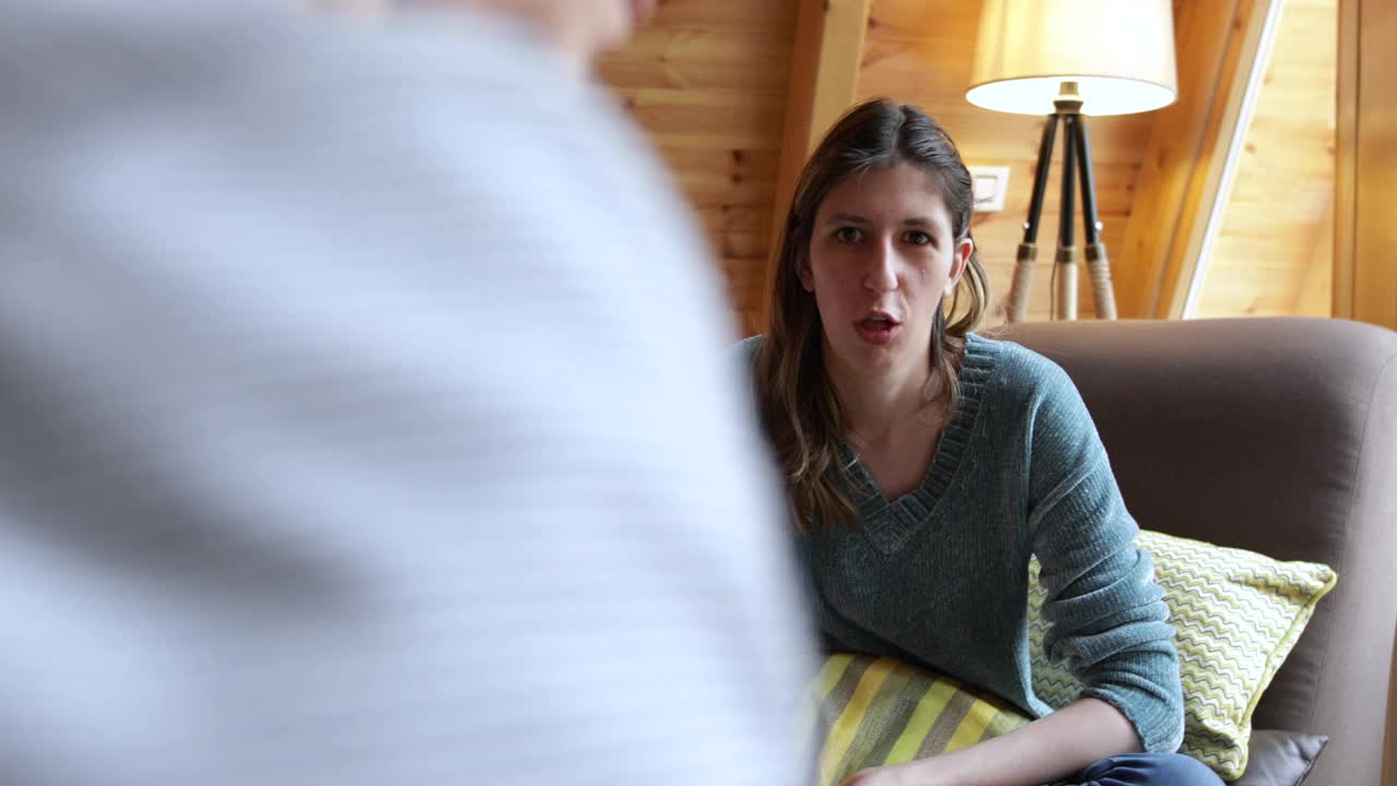 一位戴着人工耳蜗的年轻女子正在与一位心理学家交谈视频素材