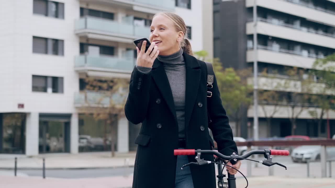 一名女子推着自行车穿过城市，同时对着智能手机说话视频素材