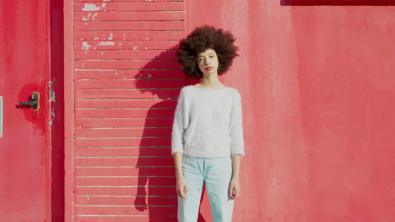 年轻伤心的女人站在红墙前视频素材
