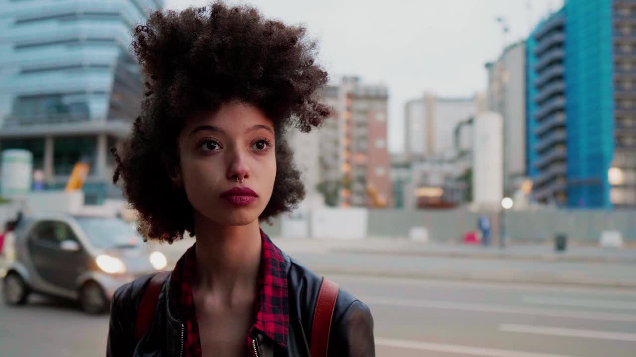 年轻女子站在城市里，望着远方视频素材