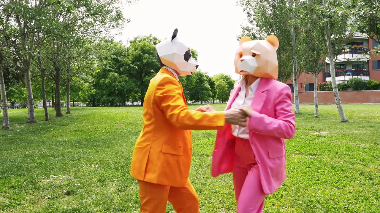 商业夫妇戴着动物面具在公园跳舞视频素材
