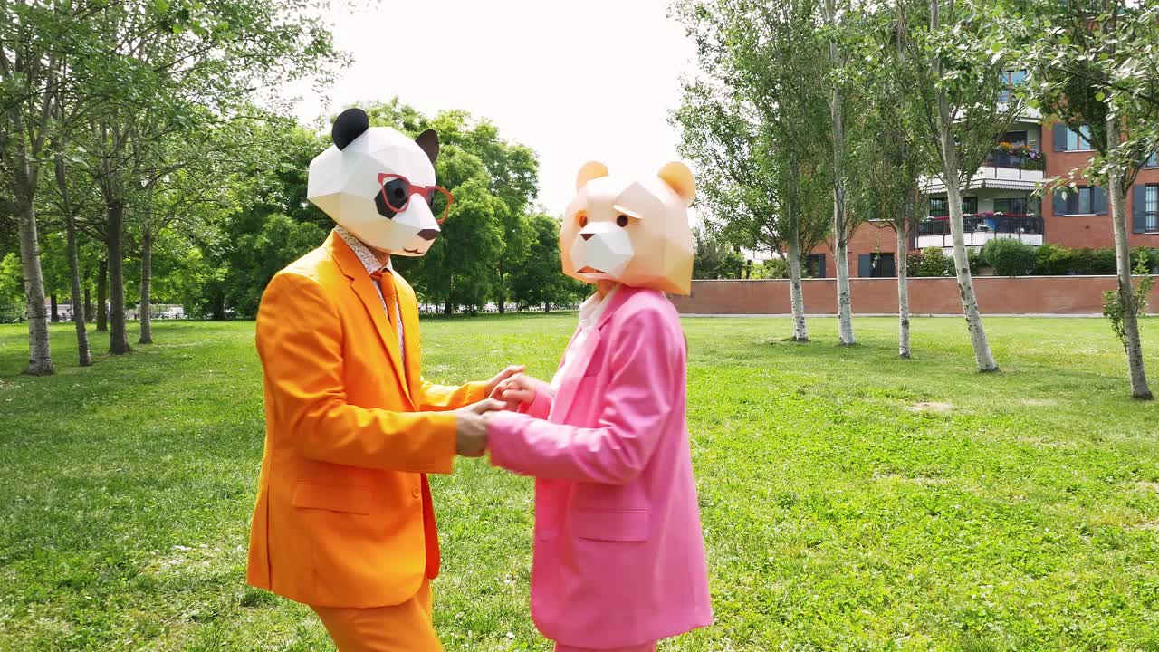 商业夫妇戴着动物面具在公园跳舞视频素材