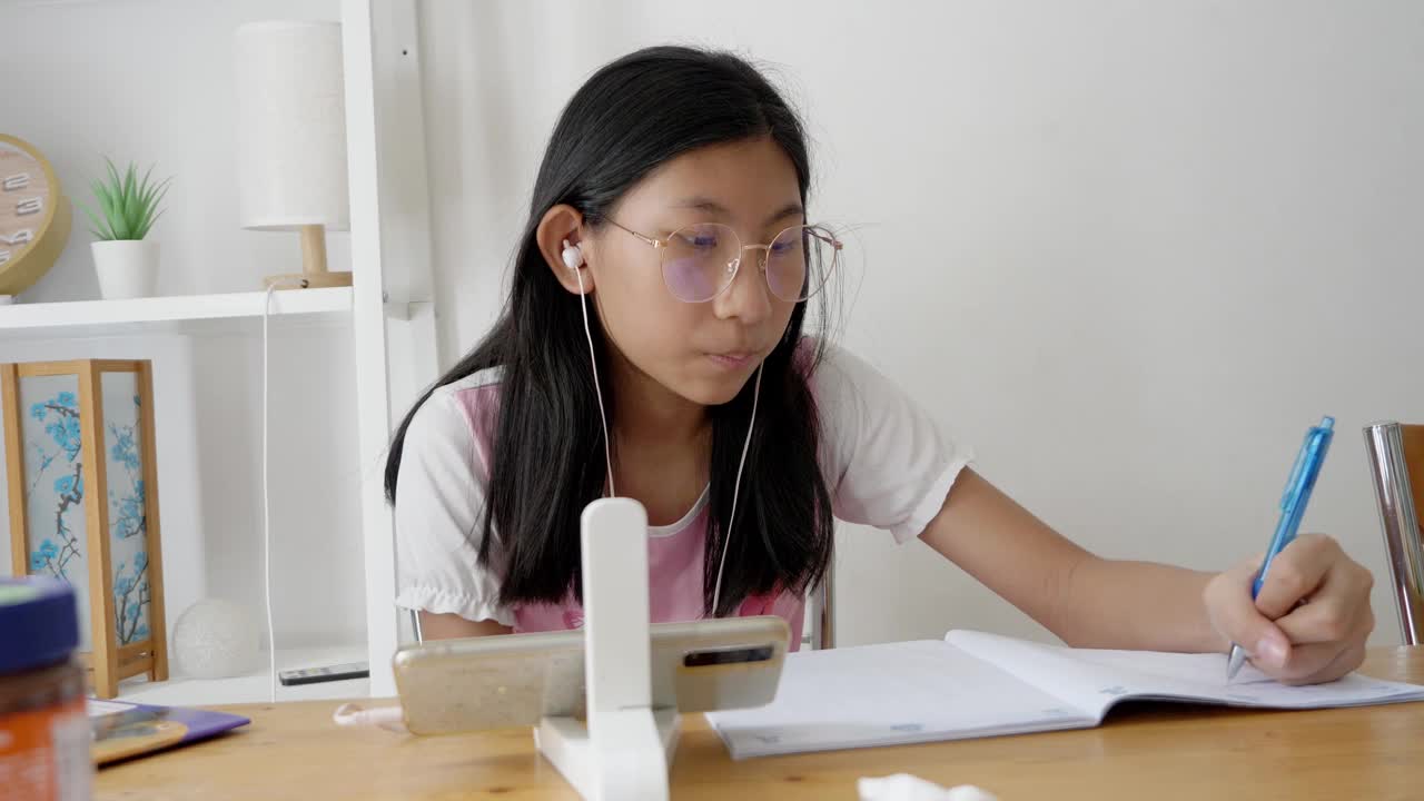 亚洲女孩在COVID-19期间在家学习在线课程，家庭隔离生活方式概念。视频下载