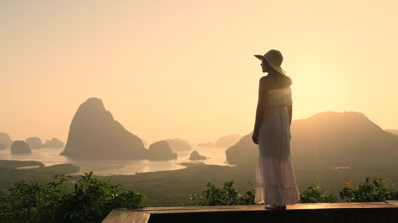年轻的女游客站在山上，欣赏着风景视频素材