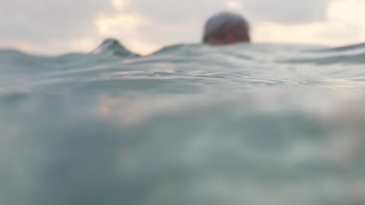 白发苍苍的老妇人早晨在海里游泳视频素材