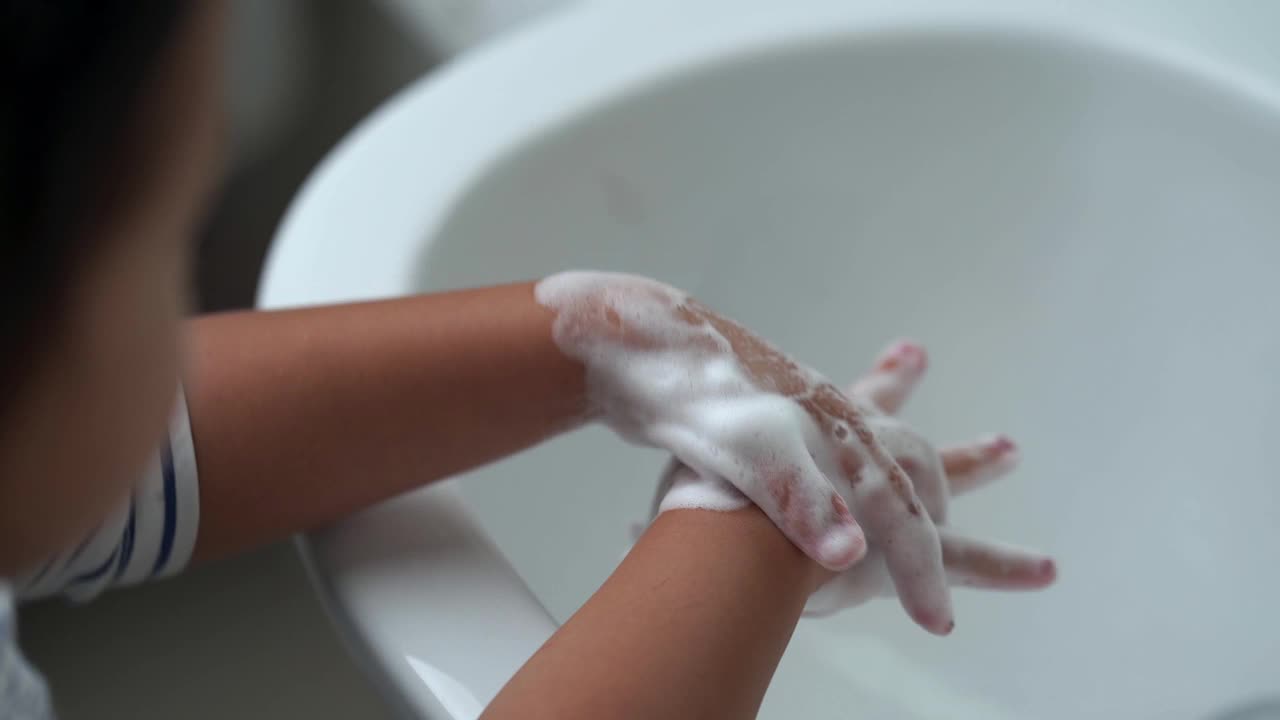 小孩在水槽里用肥皂洗手。视频素材