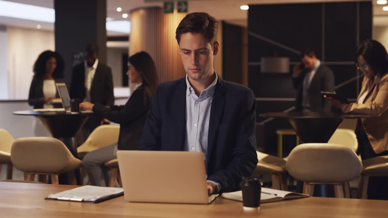 一个年轻商人在会议室里用笔记本电脑工作的4k视频片段视频下载
