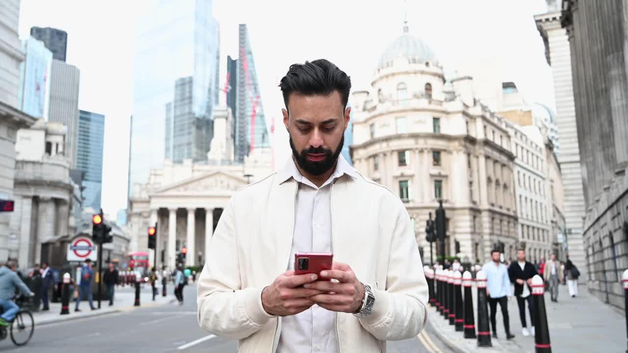 在伦敦金融城使用智能手机应用的聪明休闲商人视频素材