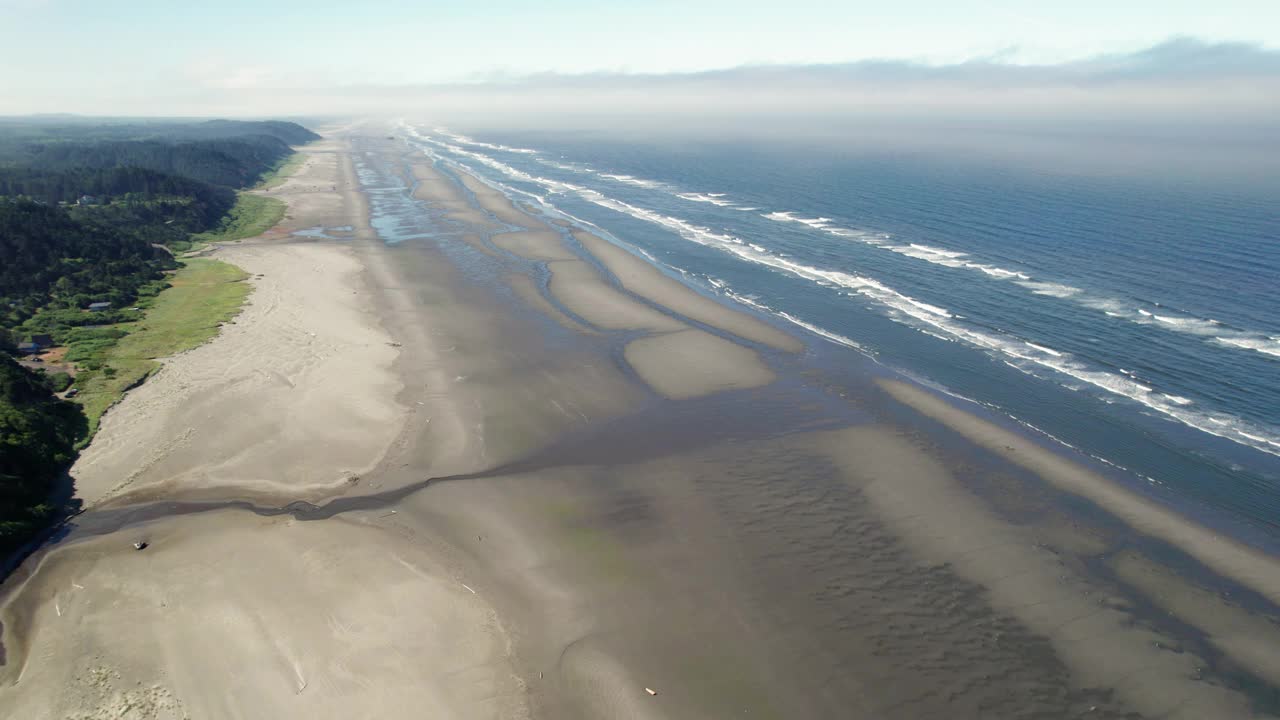 电影航拍的沙滩无限延伸到地平线与海浪翻滚视频素材