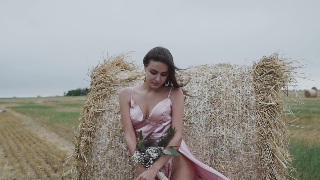 性感的女士在吹裙子手捧鲜花站在诱惑视频素材