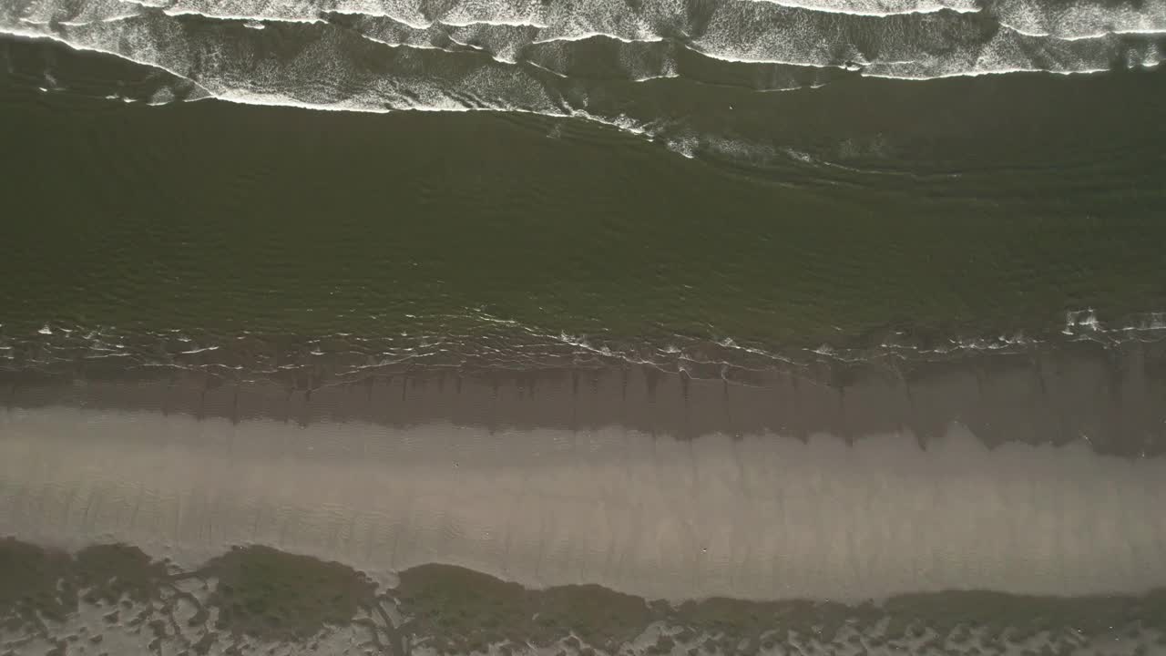 海滩鸟瞰飞行的小海浪打破层视频素材