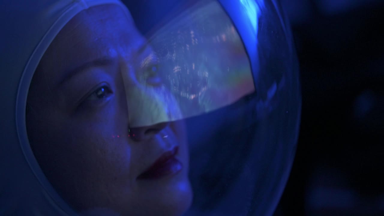 亚洲华裔女宇航员从太空飞船上透过窗户看地球视频素材