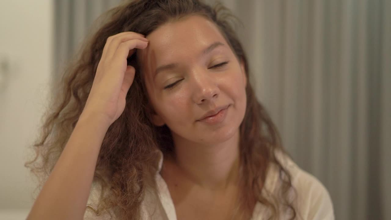 昏昏欲睡的白衬衫混血年轻女子整理头发视频素材