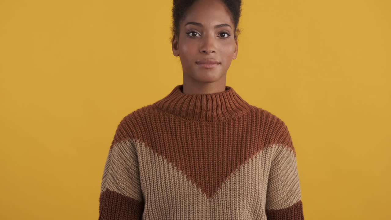 非常随意的非洲裔美国女孩的肖像，在黄色背景上快乐地展示ok手势视频下载