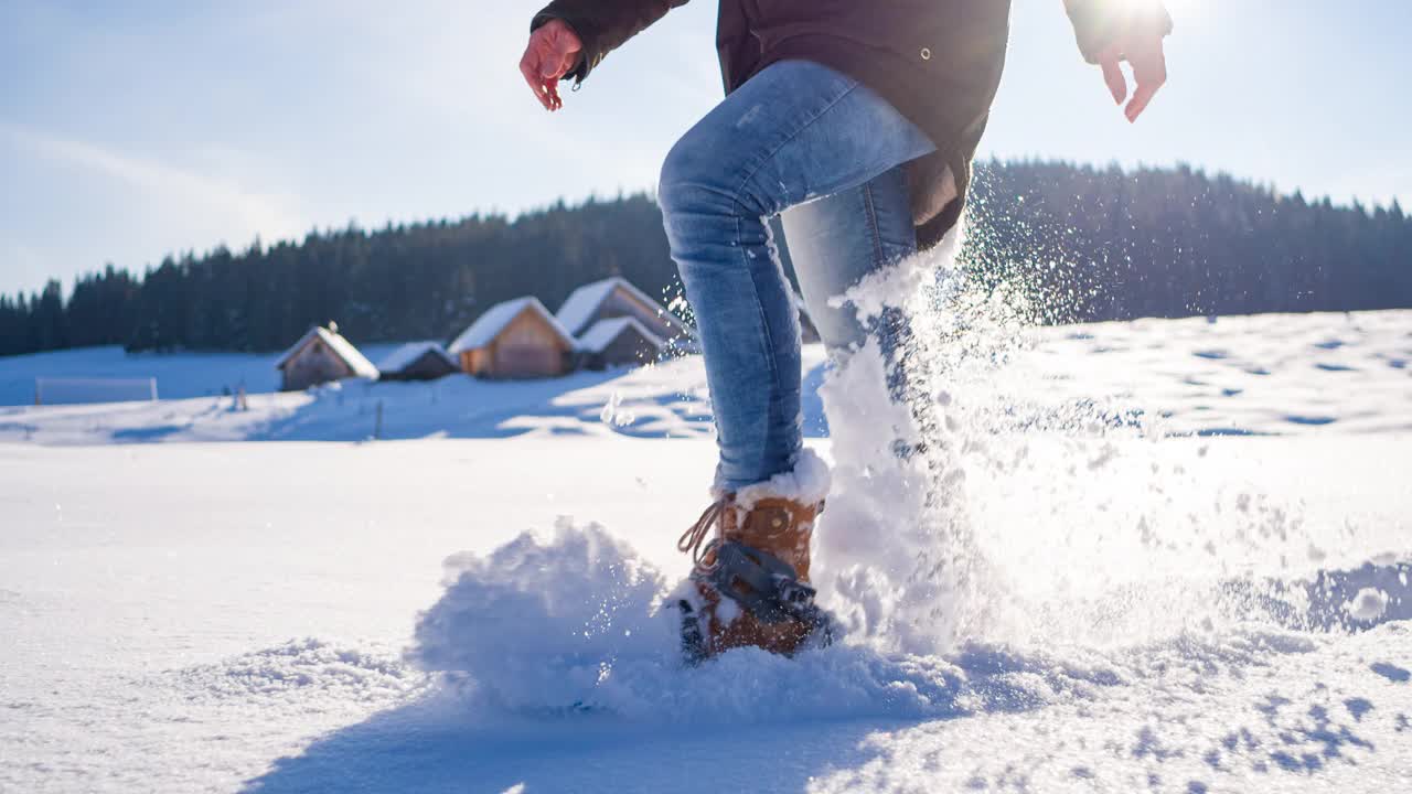 穿着雪鞋走过田园诗般的白雪覆盖的冬季风景视频下载