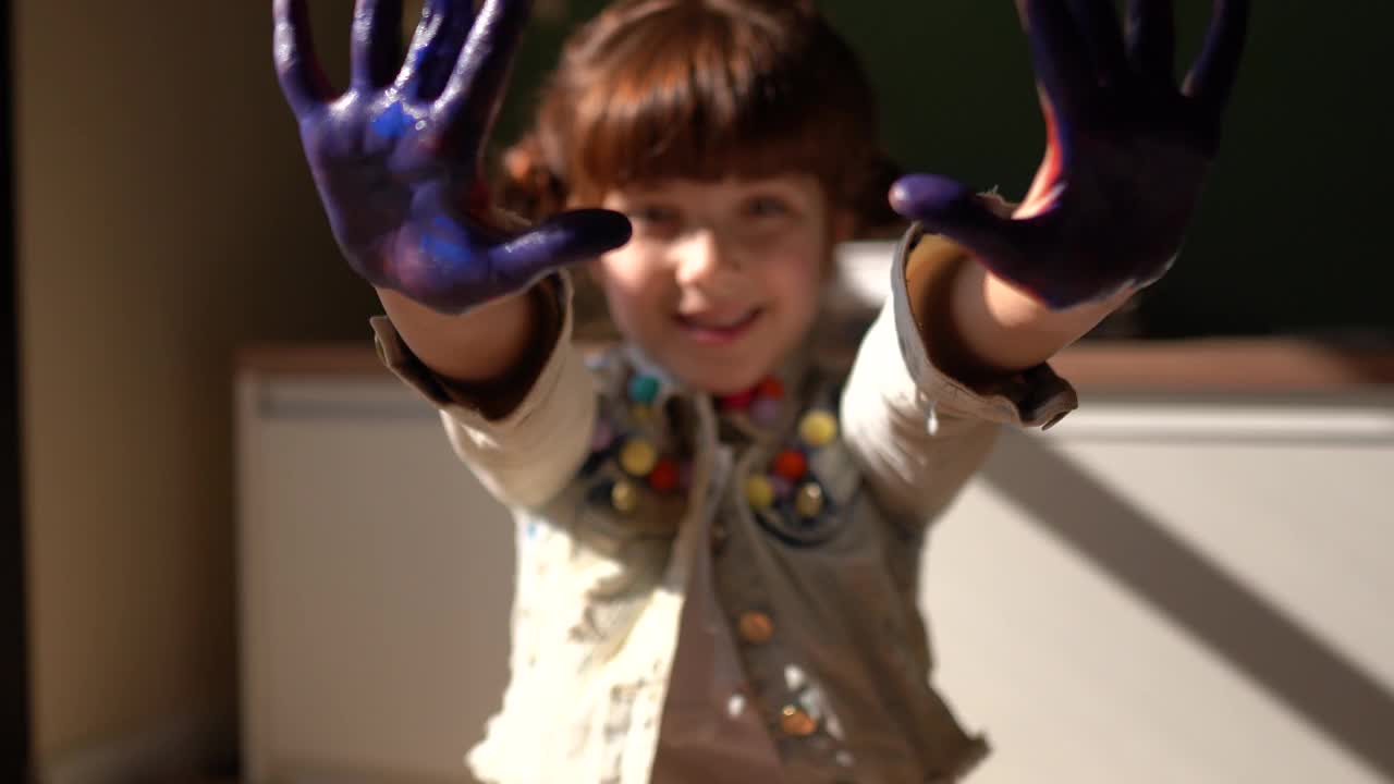 一个可爱的女孩的画像，她的手沾满了颜料视频下载