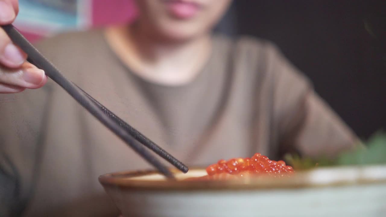 一个女人在日本餐馆吃日本菜。视频素材