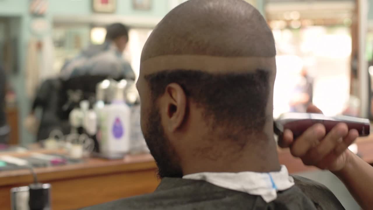 理发师在他的理发店里用剃刀给一位顾客剃头视频下载