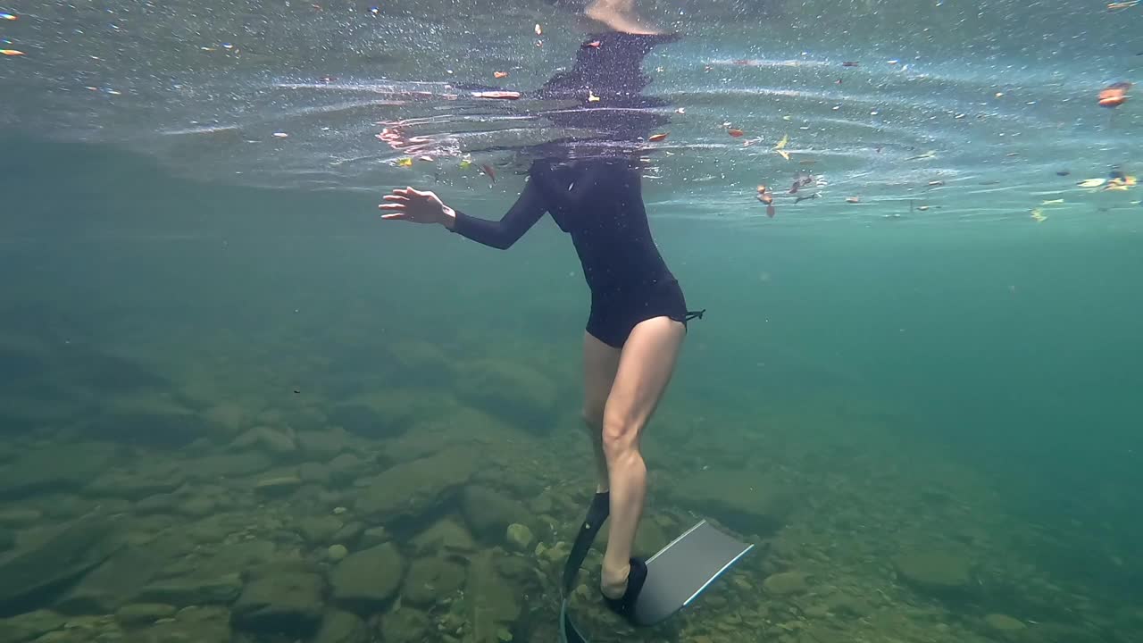 亚洲女子在清澈的水中自由潜水。视频下载