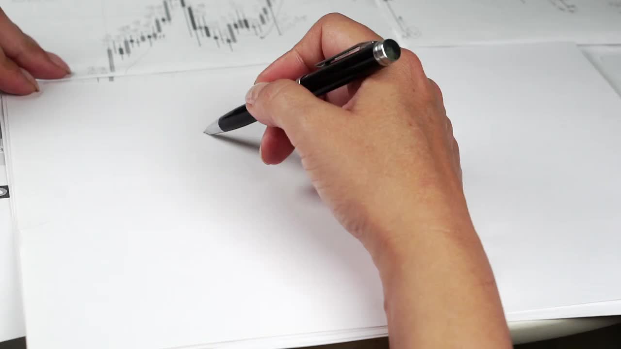 一只手在一张纸上画出了比特币标识可能的移动方向视频下载