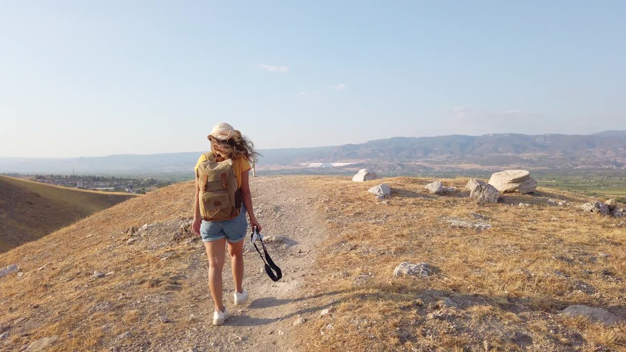 旅行者旅行者摄影师女孩正在行走，拍摄来自吕库斯老底嘉古城遗址的石灰华Pamukkale视频素材
