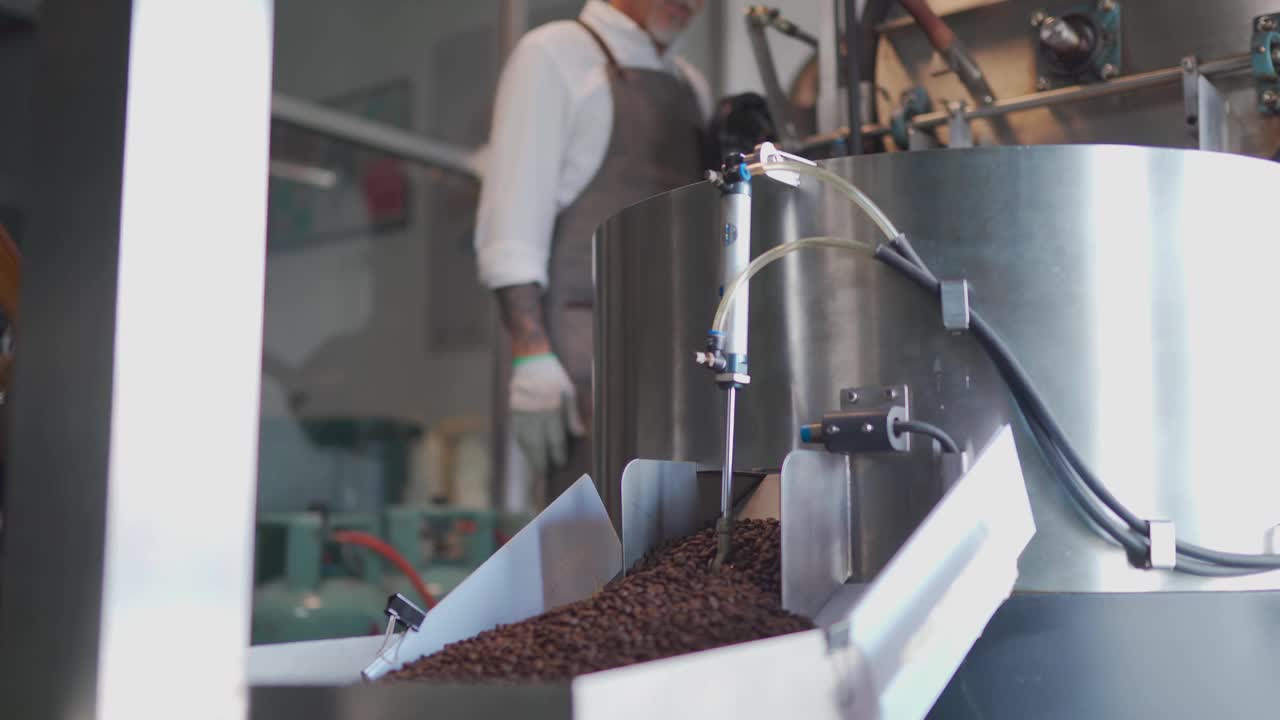 在他的工厂里，一名亚裔华裔高级技工正在检查烘培咖啡豆的去石过程视频下载