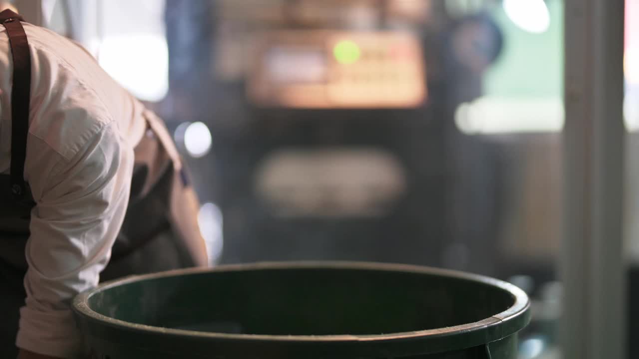 靠近中部的亚洲华人工作高级男子舀生咖啡豆装满桶称重机和混合它在工厂仓库的咖啡烘焙过程中视频下载