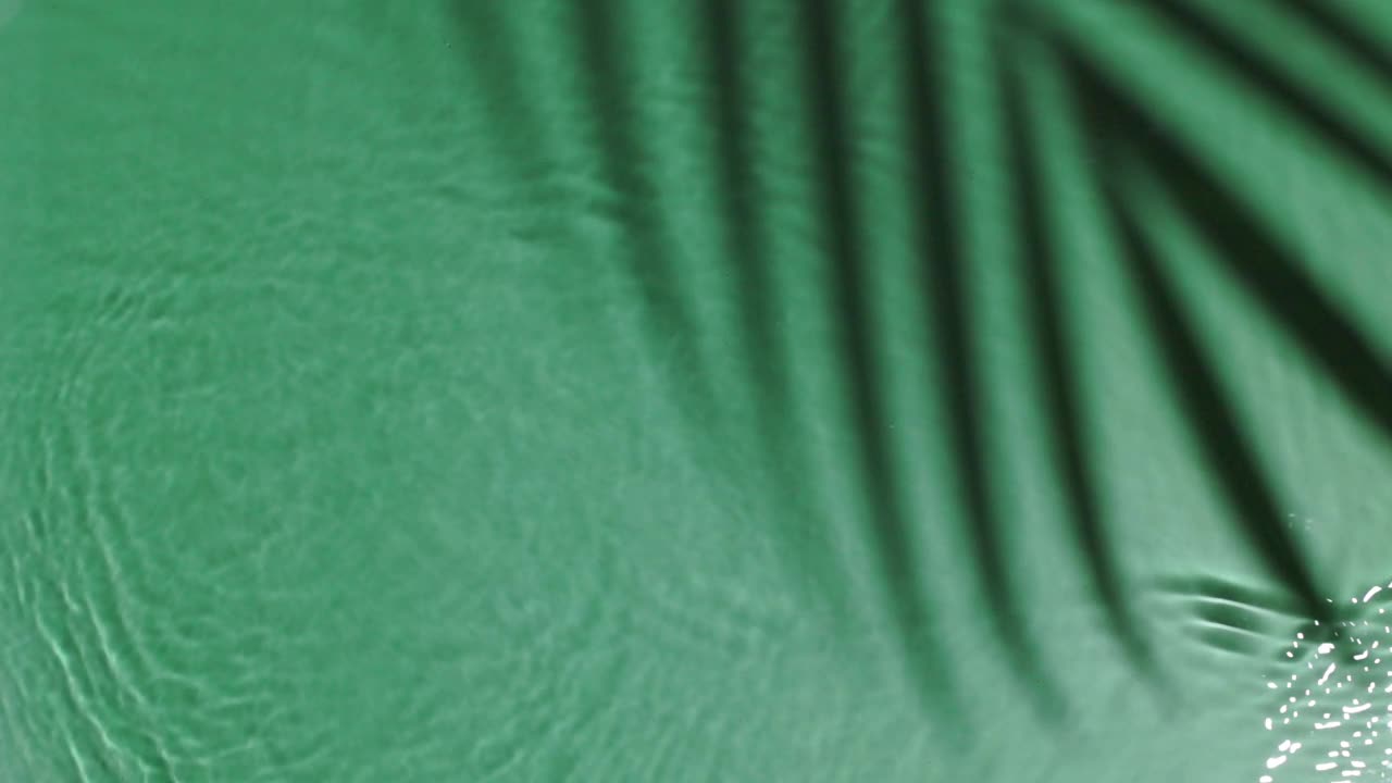 碧绿的水面纹理，棕影，涟漪，阳光下透明。背景为化妆品或水疗概念背景。本空间视频素材