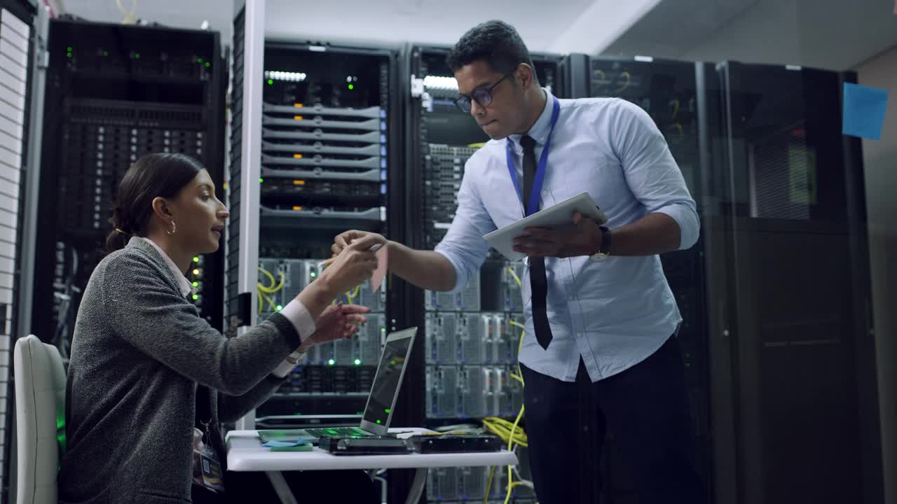 两名技术人员在服务器室一起工作的4k视频片段视频素材