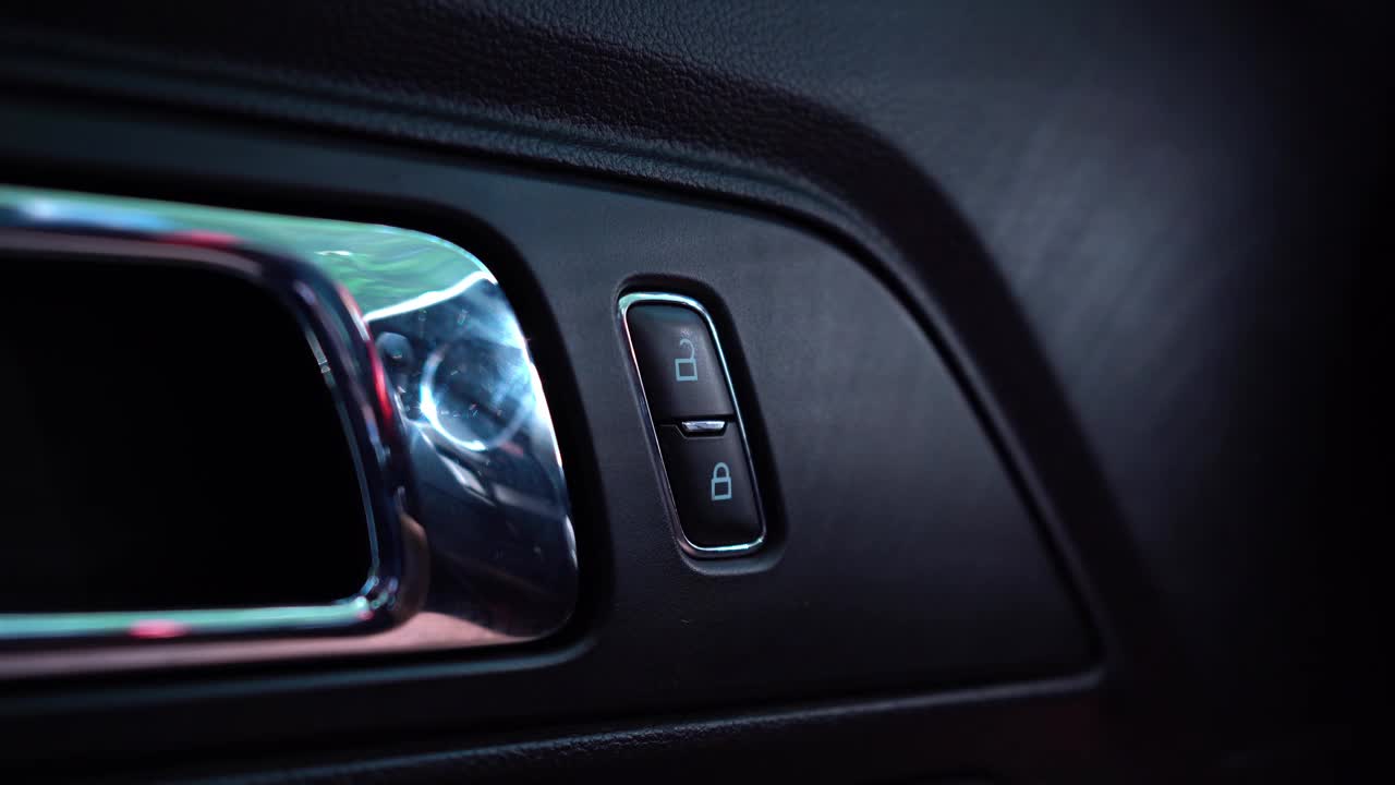 在扶手上，手按按钮为汽车门内窗户的电动升降机构。4 k视频。视频素材