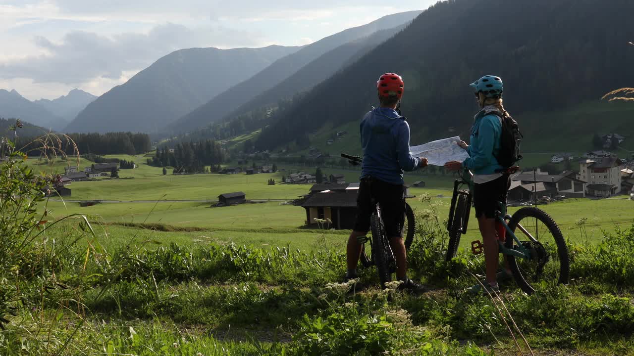 山地自行车手在瑞士阿尔卑斯山骑车时查阅地图视频下载