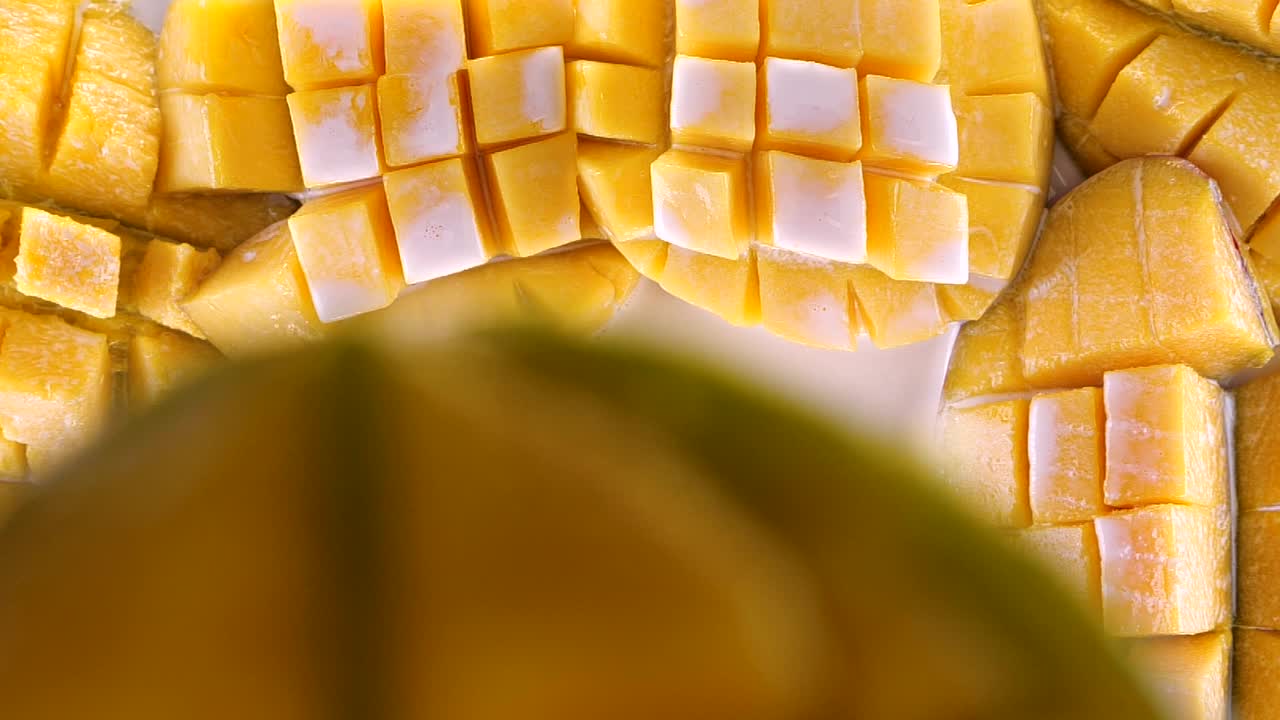 芒果以超级慢动作掉落并溅入奶油或酸奶中。带牛奶的热带水果。视频下载
