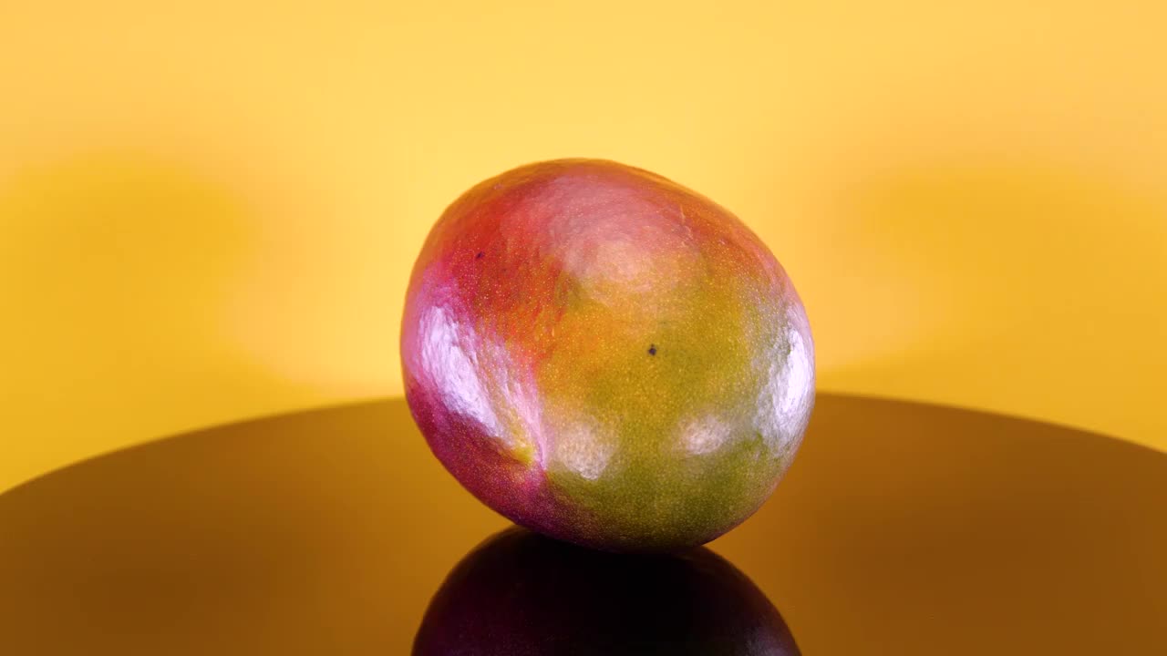 黄色背景上的芒果。大而成熟的芒果热带水果视频素材