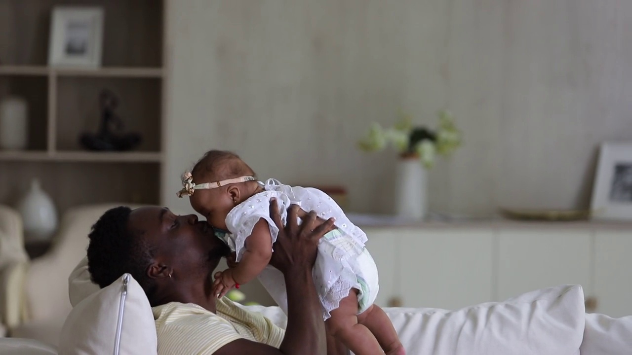深情的非洲爸爸和混血儿女儿玩耍亲吻。父亲和孩子视频素材