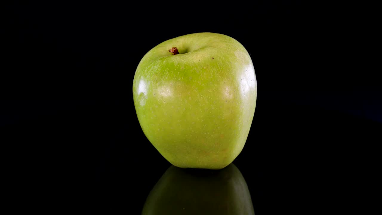 4K黑底绿苹果。成熟、完美、美味的青苹果。视频素材