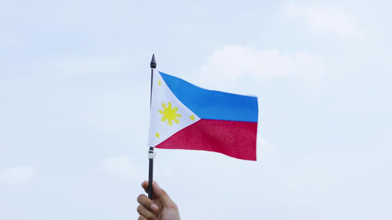 晴朗的天空下，无名之手举着菲律宾国旗视频下载