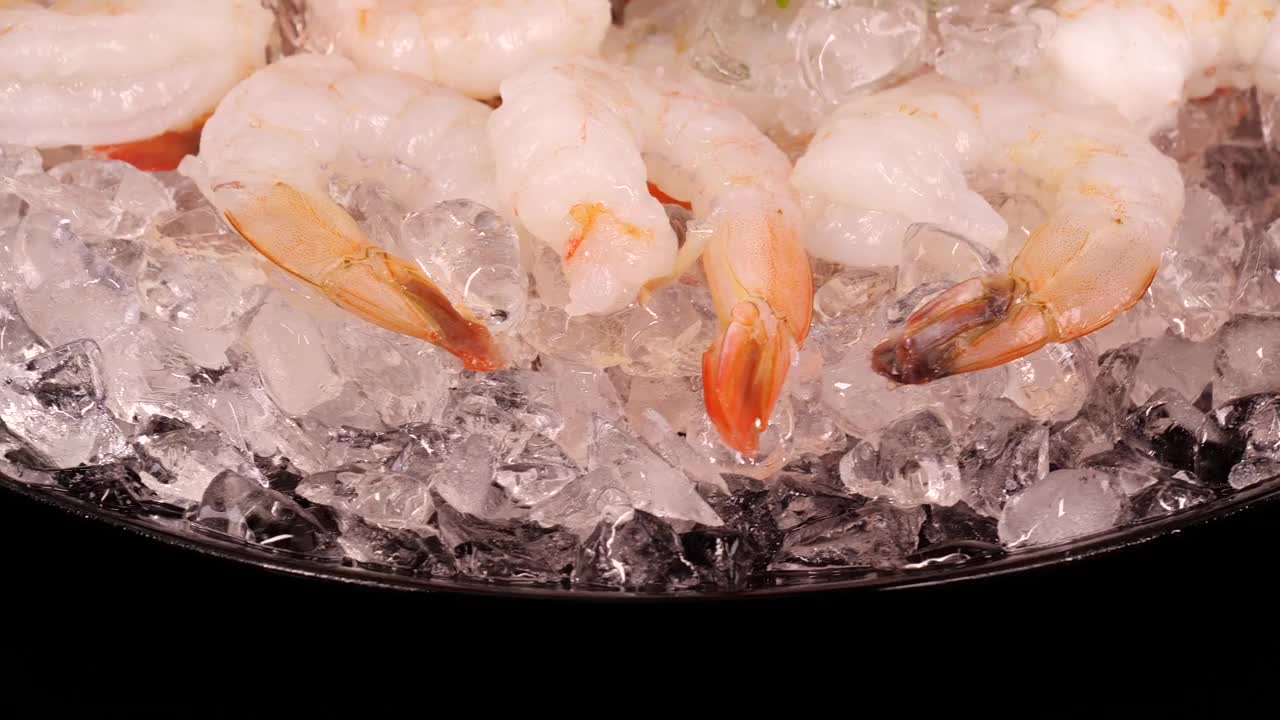 虾在冰上。一盘大虾，加碎冰，柠檬片和新鲜欧芹。新鲜健康的海鲜，作为地中海饮食的成分。视频素材