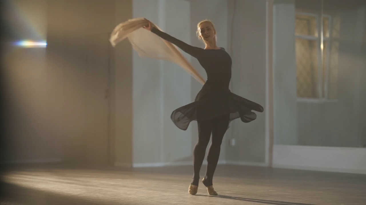 才华横溢的苗条的美丽的芭蕾舞演员在背光雾在慢动作与手围巾脚尖旋转。广角拍摄的优雅优雅的白人女子在室内跳舞。美与艺术观念。视频下载
