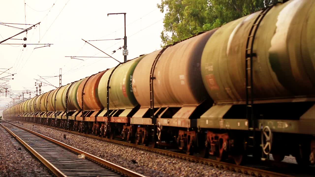 货运列车带着油罐车在火车站上眺望日落时分的景色。视频素材