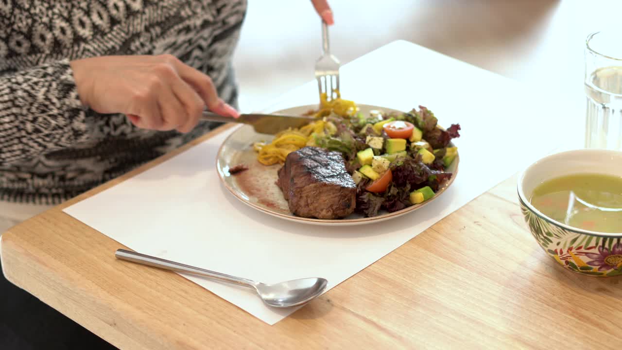 拉丁妇女午餐吃一盘美味的蛋白质和蔬菜视频下载