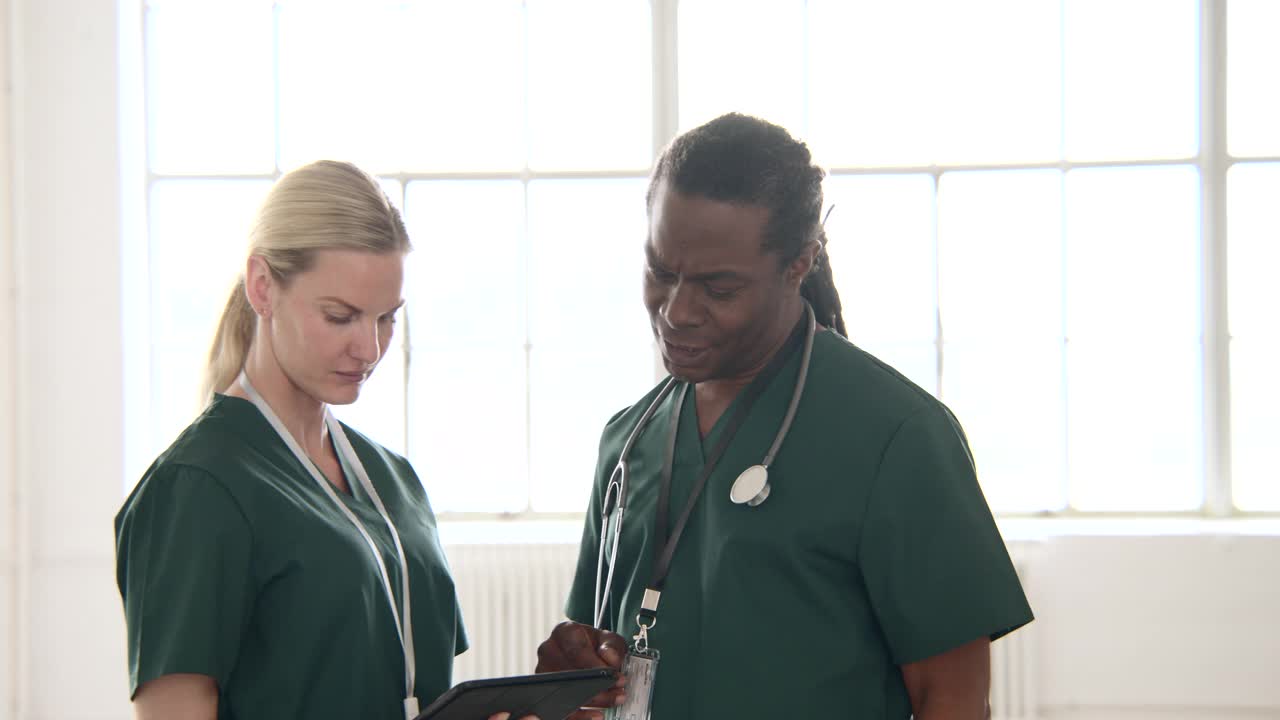 两名医护人员拿着数字平板电脑交谈视频下载