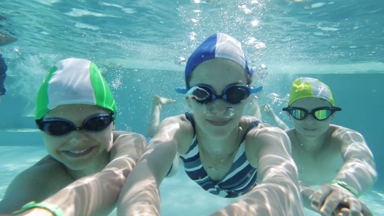 三个快乐的孩子在游泳池里游泳视频下载
