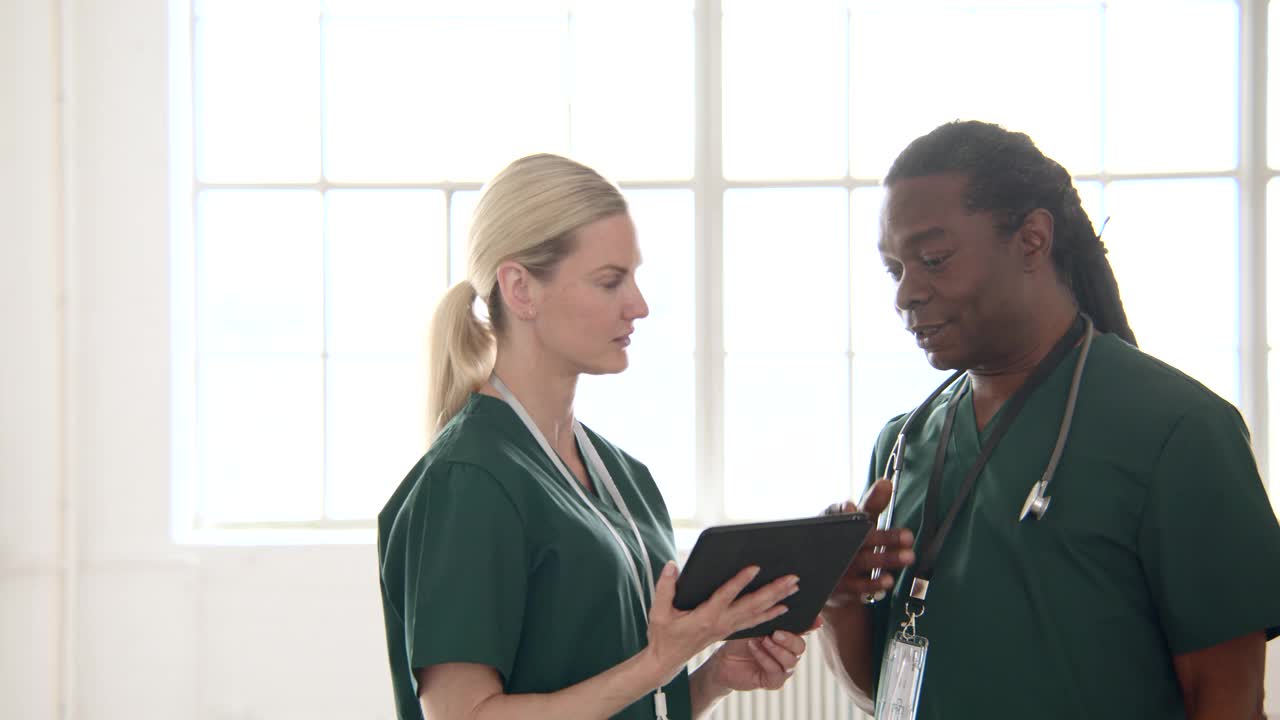 两名医护人员拿着数字平板电脑交谈视频下载