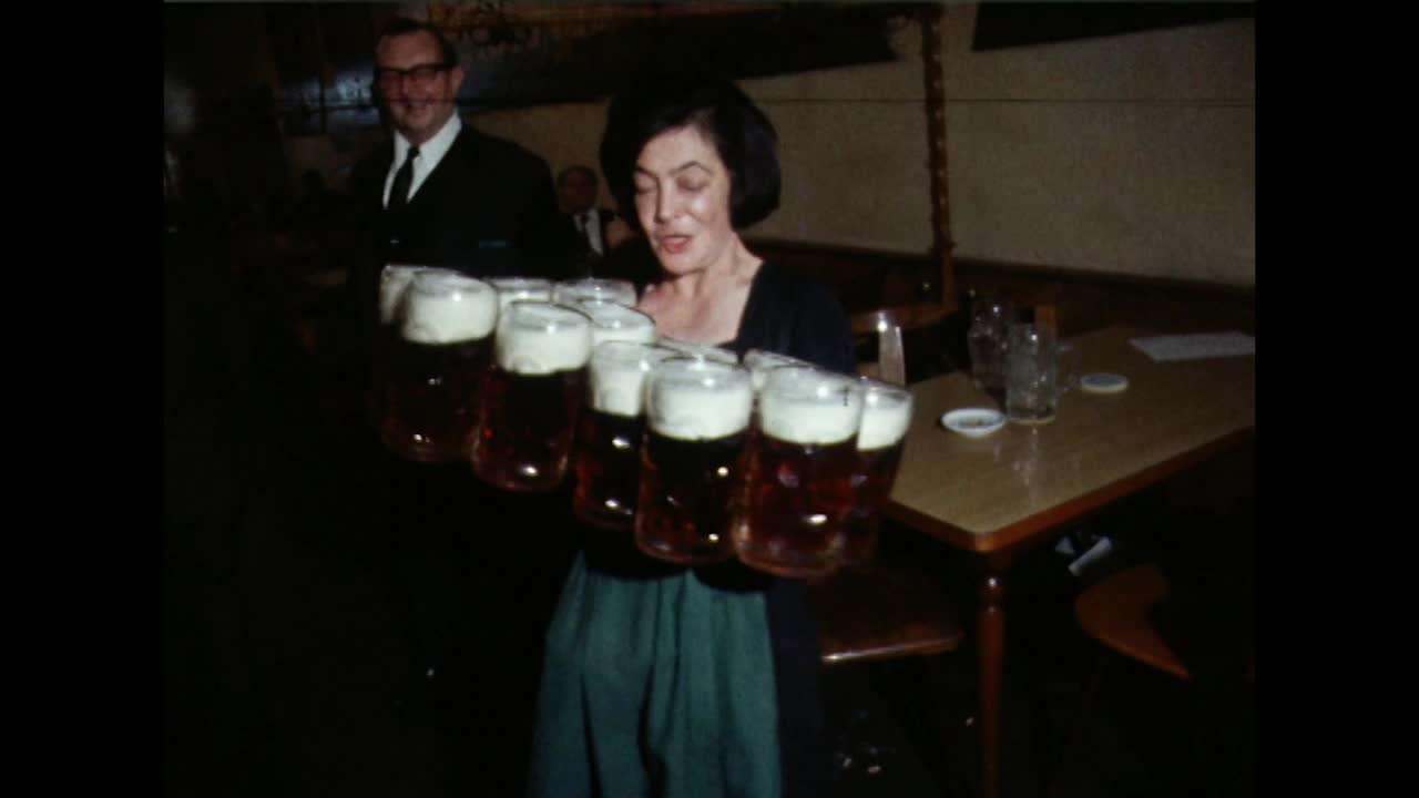 啤酒节期间，酒吧女服务员端着一打啤酒杯;1969视频下载
