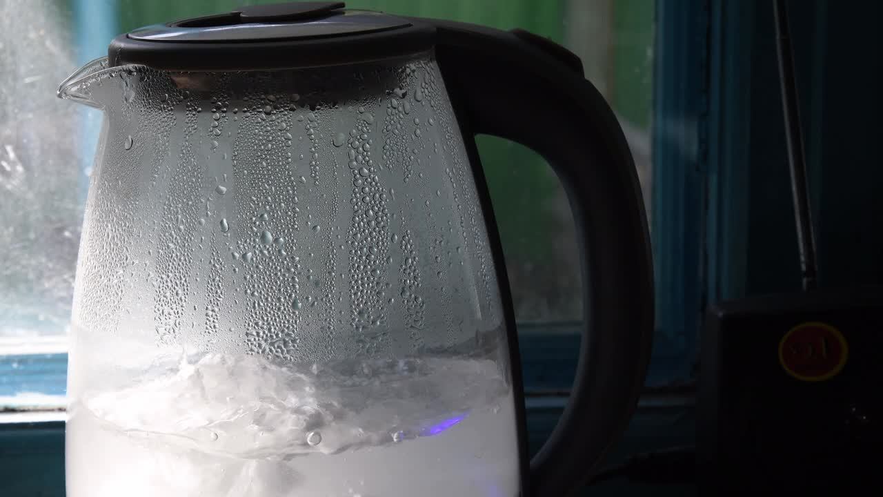 厨房窗户旁边的透明水壶里有沸水视频素材