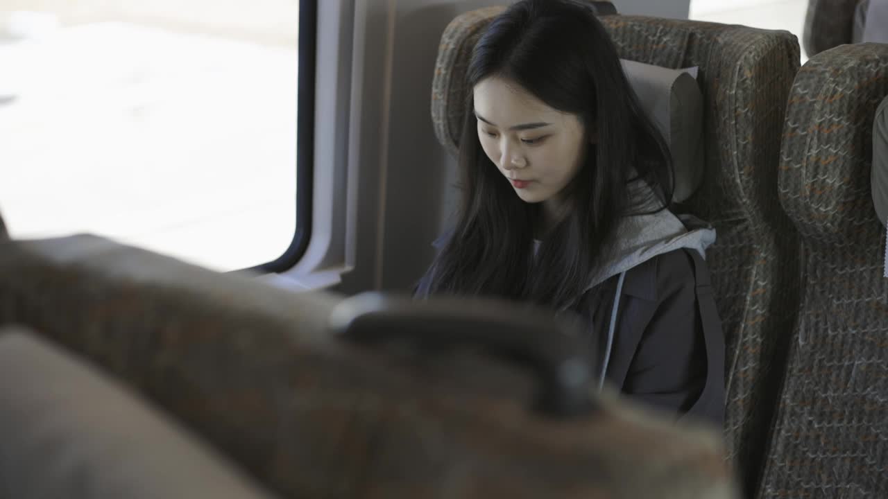 亚洲女孩在高铁上看智能手表视频下载