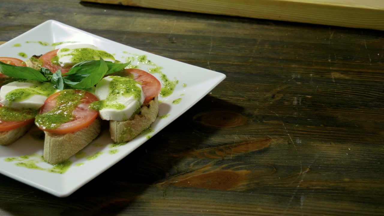 意式烤面包配蕃茄，马苏里拉芝士，香蒜沙司，洋葱，新鲜罗勒。4 k视频下载