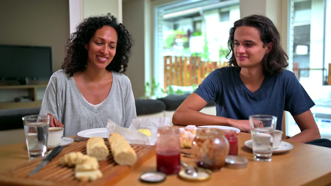 快乐的拉美裔母亲和儿子一起在家吃法式早餐视频素材