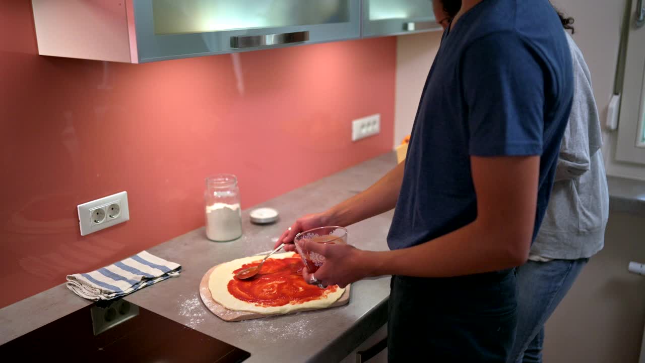 西班牙裔母亲和儿子在家庭厨房准备披萨视频下载